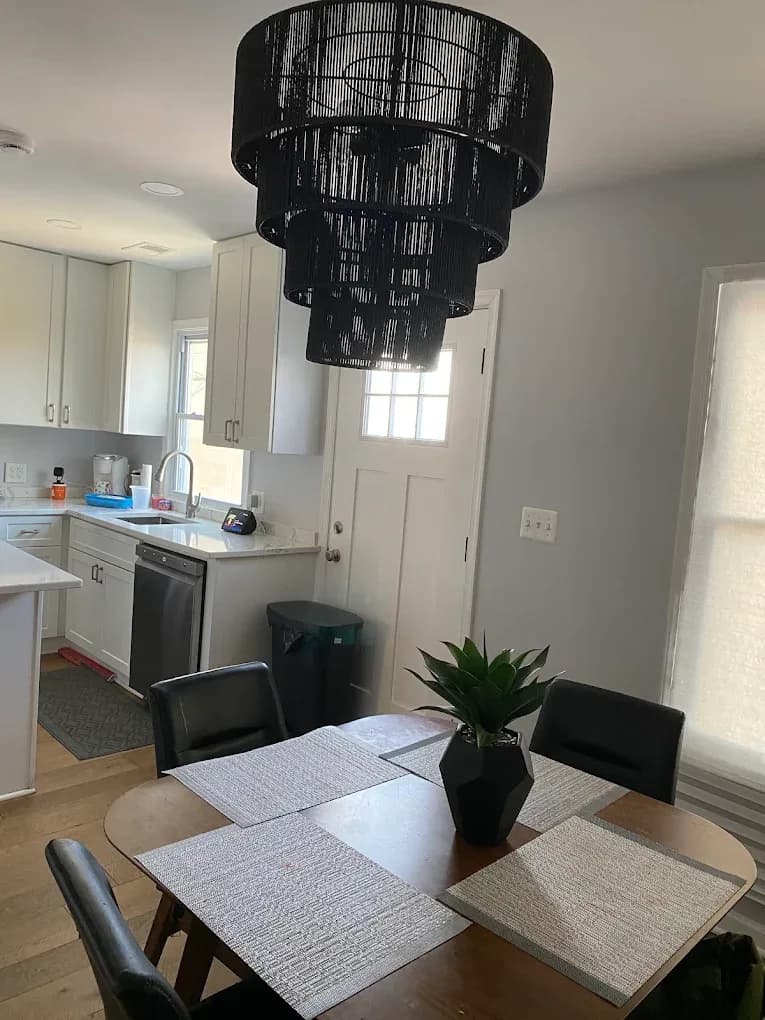 A finished rental house kitchen and dining area with white cabinets and clean counters